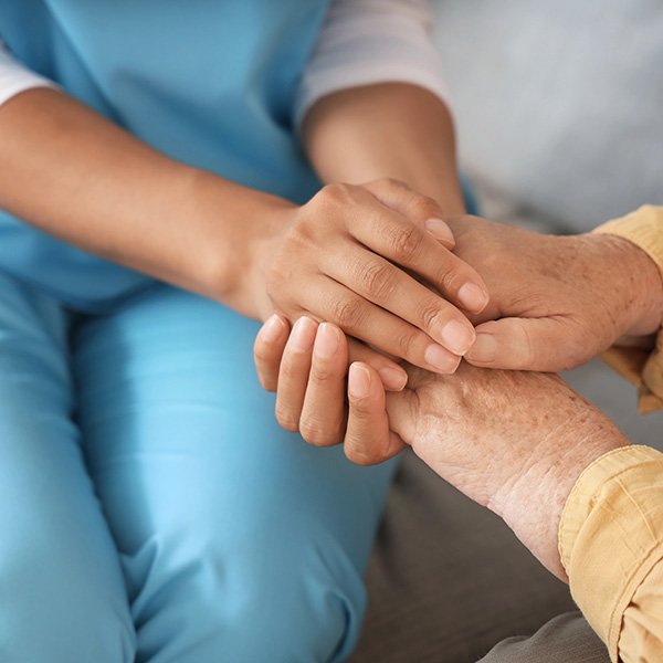 Caregiver holding hands with elderly patient