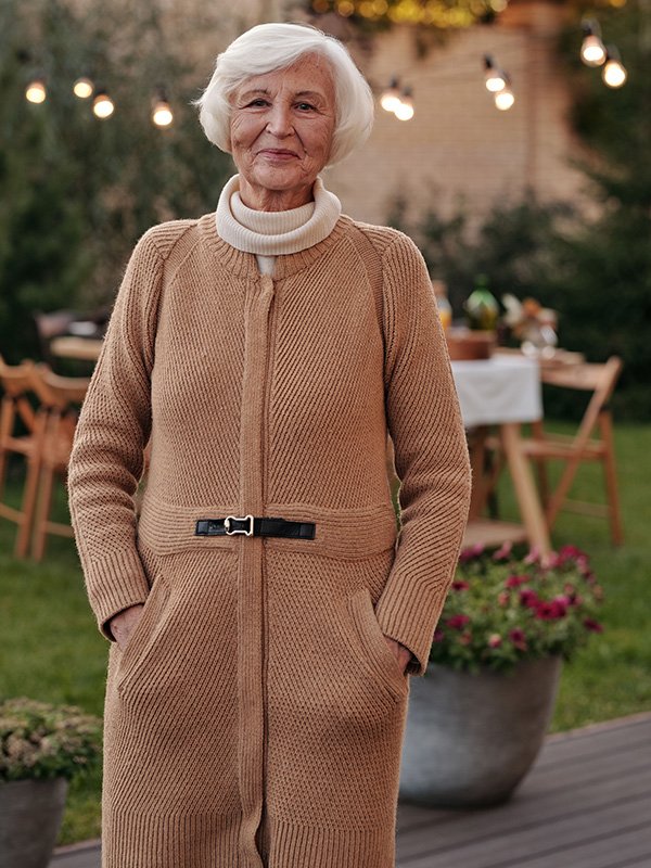 Elderly lady in backyard with dining set
