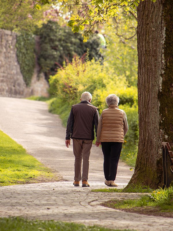 Elderly couple walking down a path
