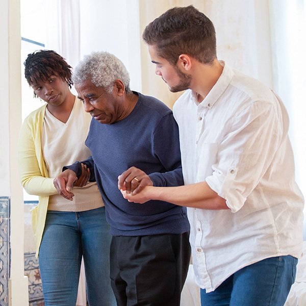 Elderly man with daughter and caregiver